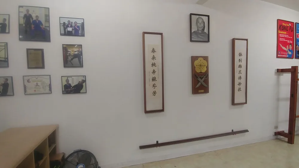 Framed photographs, certificates and calligraphy scrolls on the training hall wall